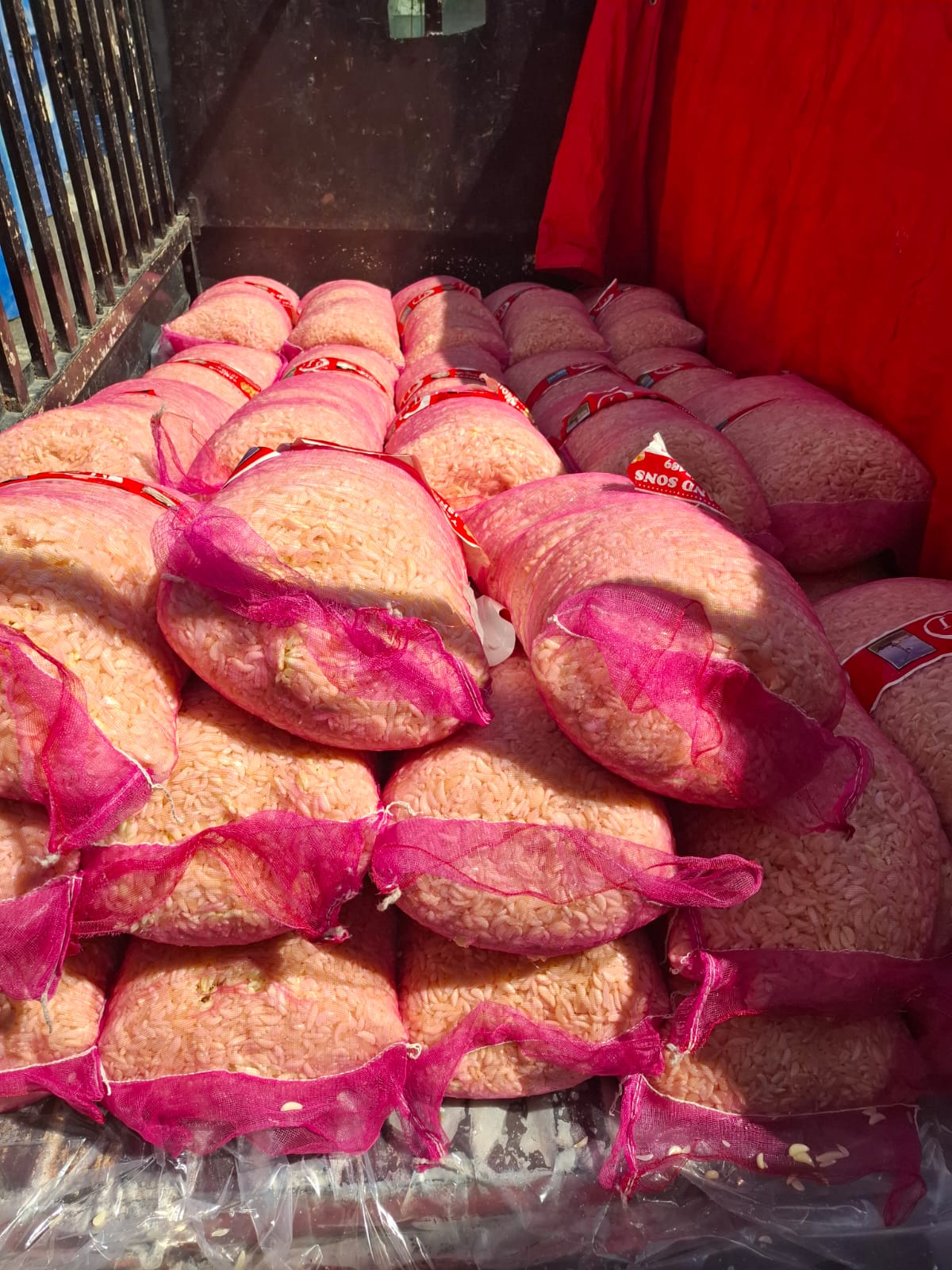 Peeled garlic in pink mesh bags on delivery vehicle — Ali Wasim Farm
